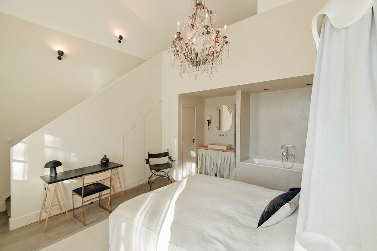 suite hôtelière, suite de prestige, suite haut de gamme, chambre d’hôtel de charme, hébergement de luxe, hébergement de caractère, rénovation hôtelière, architecture hôtelière, design hôtelier, hôtel de charme, domaine de réception, domaine événementiel, suite événementielle, hébergement pour mariage, hébergement pour séminaire, suite romantique, chambre premium, expérience hôtelière haut de gamme.  rénovation patrimoine, réhabilitation patrimoine bâti, rénovation dépendances de château, château de la Banquière, architecture du patrimoine, rénovation de prestige, conservation du patrimoine, valorisation de l'existant, architecture contemporaine et patrimoine, restauration bâtiment ancien, domaine historique, réhabilitation domaine de caractère.  charpente apparente, poutres anciennes, poutres en bois massif, structure historique conservée, matériaux anciens, pierre et bois, authenticité architecturale, volumes existants, rénovation respectueuse du patrimoine, détails architecturaux, matériaux nobles, caractère historique, charme de l'ancien, patrimoine rénové.  suite sous charpente, chambre avec poutres apparentes, volume cathédrale, plafond mansardé, architecture intérieure patrimoniale, chambre de caractère, suite en double hauteur, architecture intérieure haut de gamme, aménagement sur mesure, design intérieur contemporain, décoration raffinée, élégance intemporelle, ambiance chaleureuse, atmosphère intimiste, confort hôtelier.  mobilier sur mesure, décoration haut de gamme, design contemporain, architecture intérieure, aménagement intérieur, chambre minimaliste, matériaux naturels, finitions soignées, éclairage décoratif, miroir design, mobilier intégré, suite contemporaine, luxe discret, raffinement architectural, expérience client premium.  architecte patrimoine Montpellier, architecte patrimoine Nîmes, architecte patrimoine Perpignan, rénovation château Montpellier, rénovation domaine historique, rénovation hôtel de charme, rénovation suites hôtelières, réhabilitation patrimoine Occitanie, architecte Occitanie, agence d'architecture patrimoine, maîtrise d'œuvre patrimoine, rénovation de prestige Occitanie.