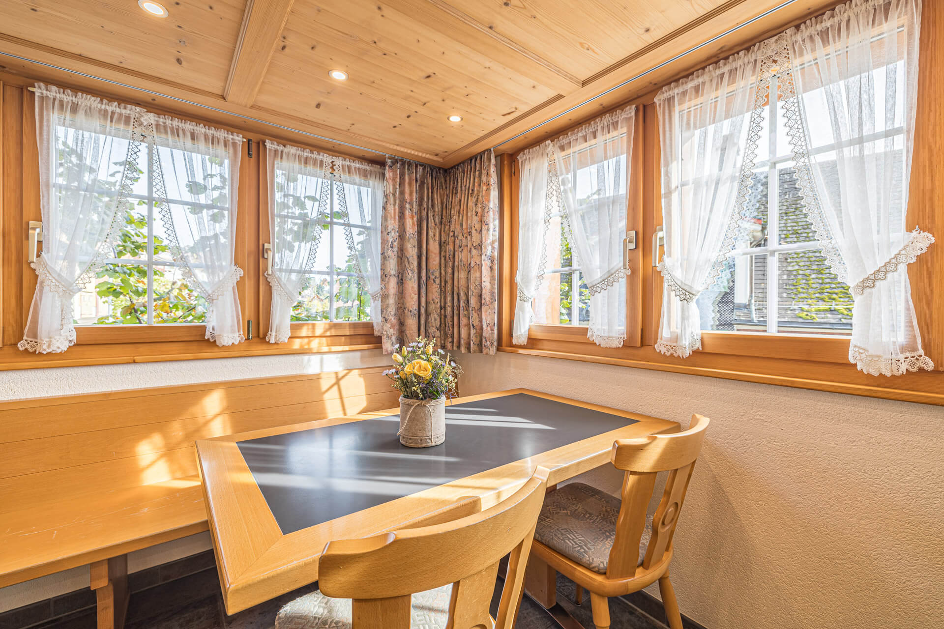 Gemütliche Gaststube des Hörnli Hembergs mit Holzvertäfelung und Blumen