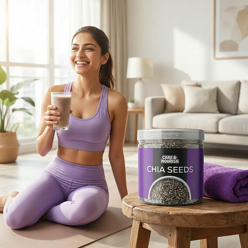 A woman in lavender activewear sits on a yoga mat in a bright living room while holding a glass of chia seed smoothie, with a container of chia seeds and a rolled purple towel nearby.