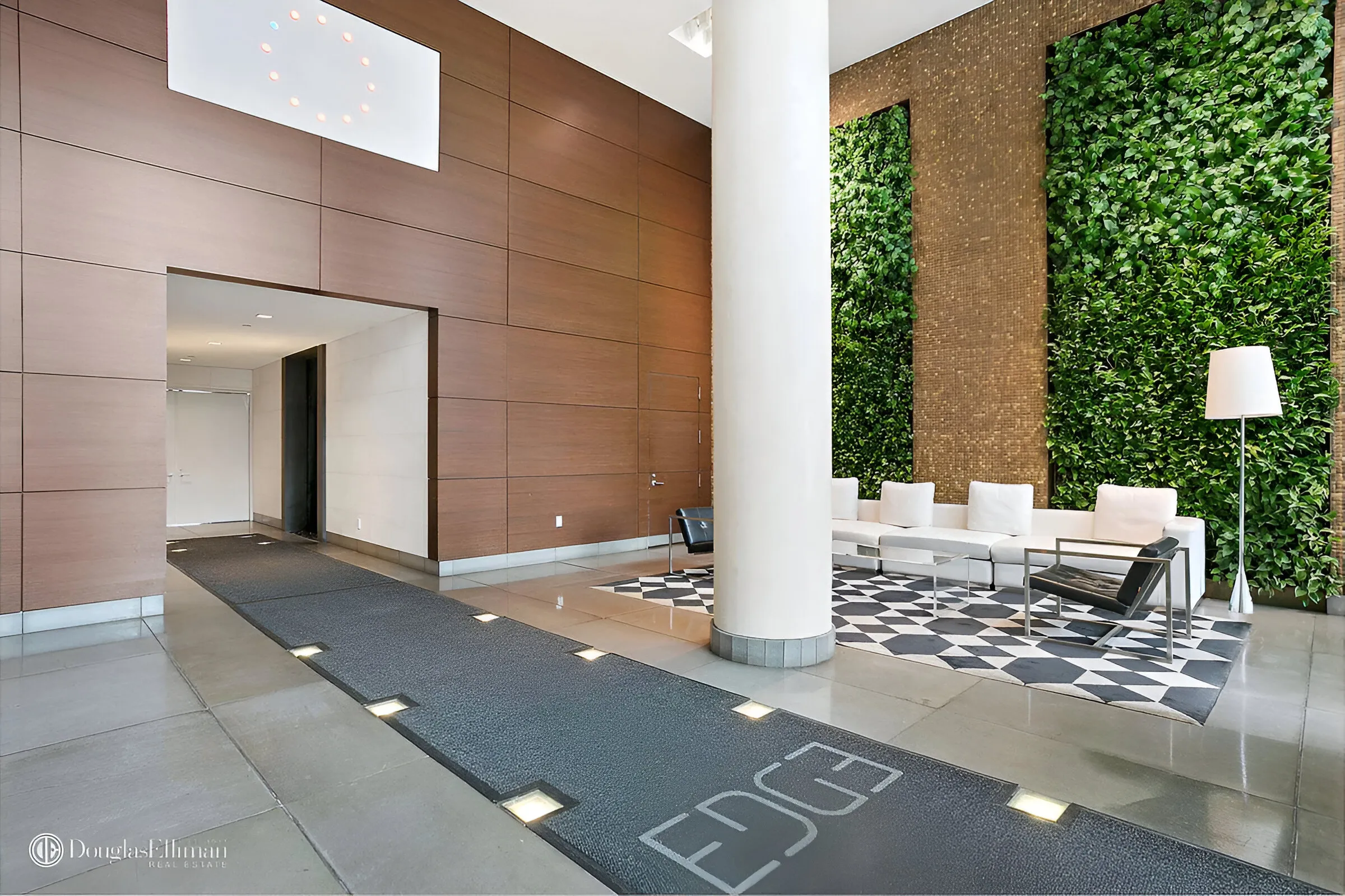 A contemporary lobby featuring a vibrant green wall, creating a fresh and inviting atmosphere.