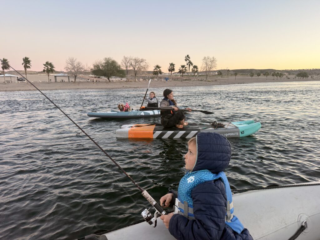 Fishing from the boat on the Colorado River with paddleboarders nearby