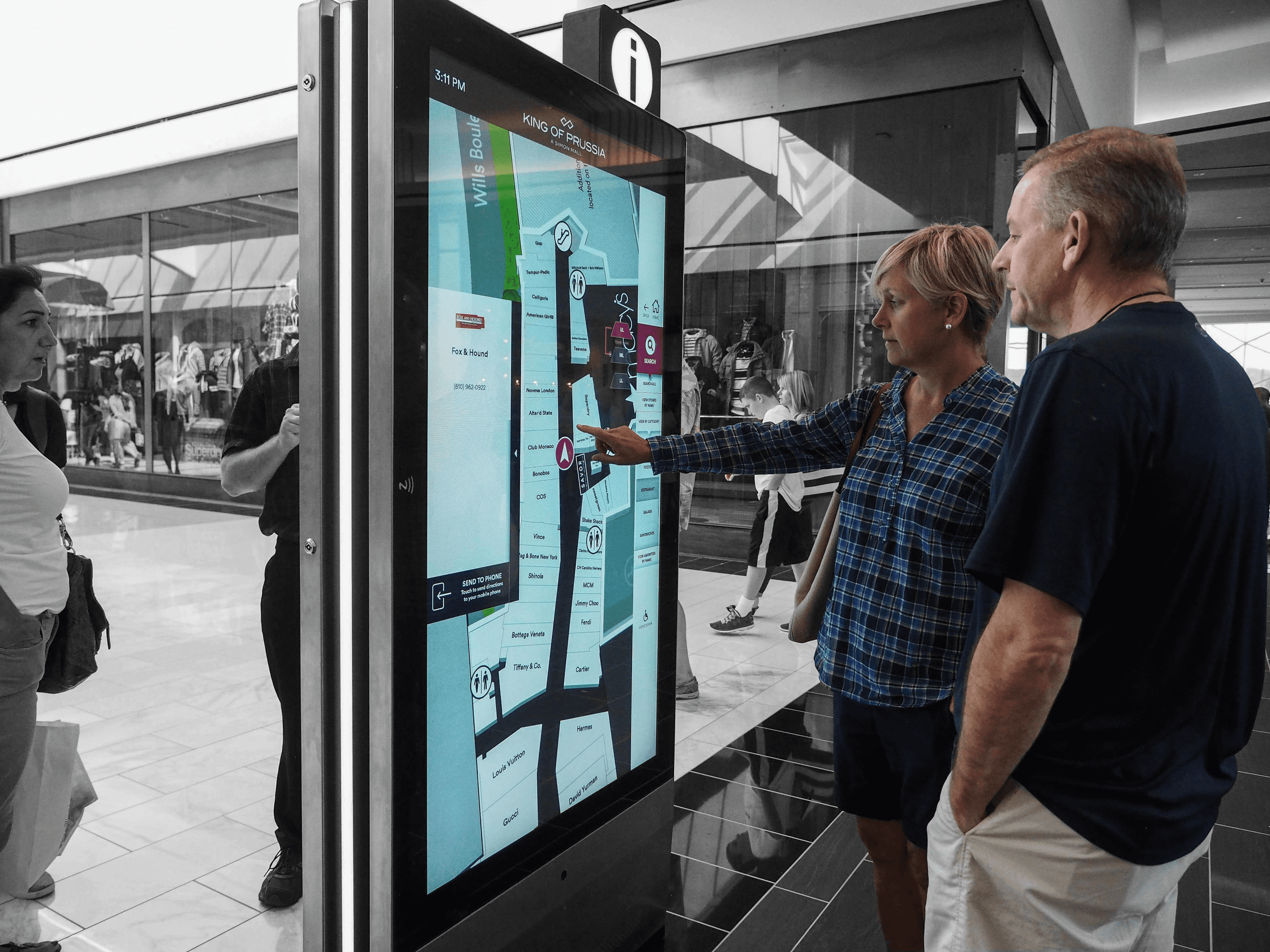 People use an interactive kiosk in a mall