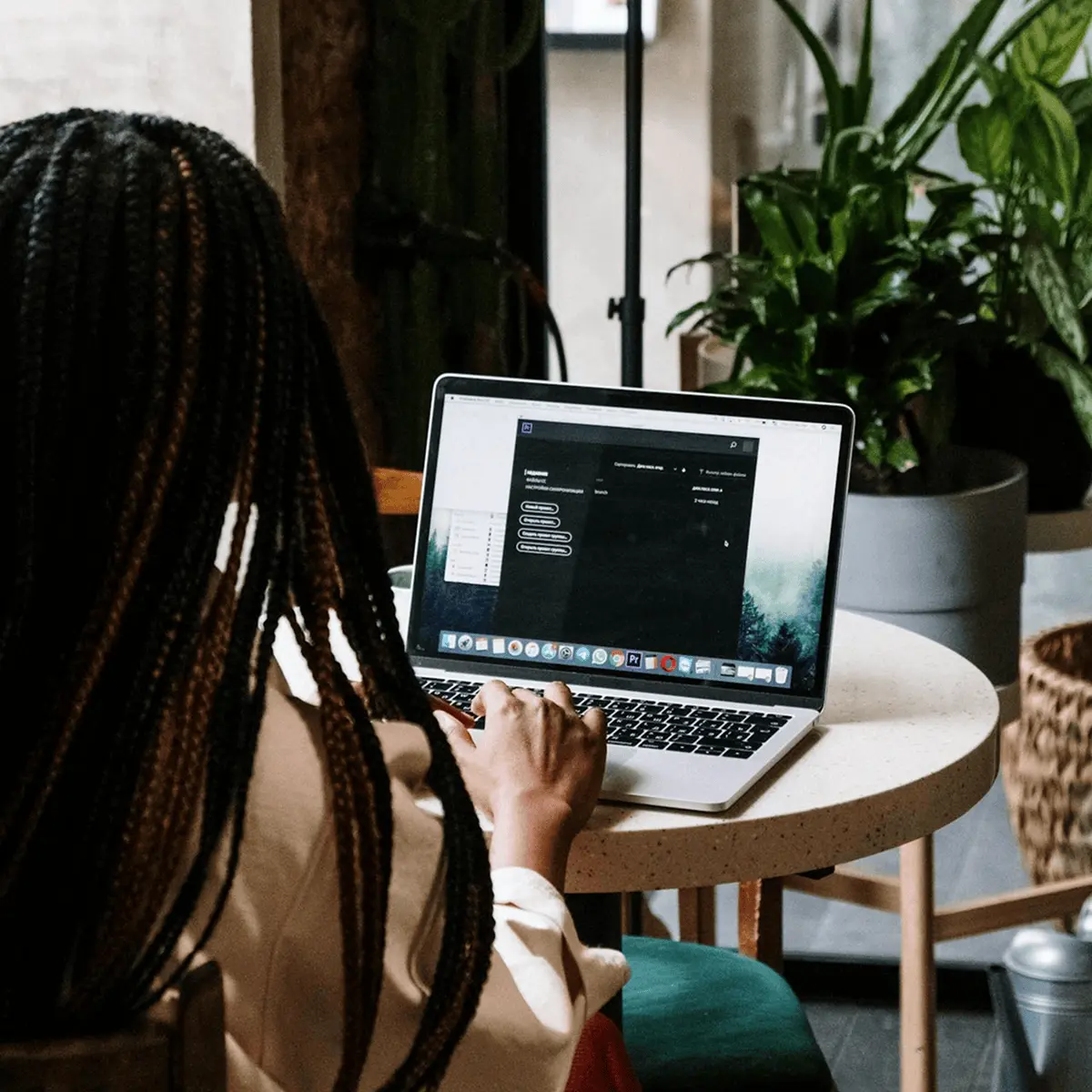 A woman working on a laptop at a cafe.