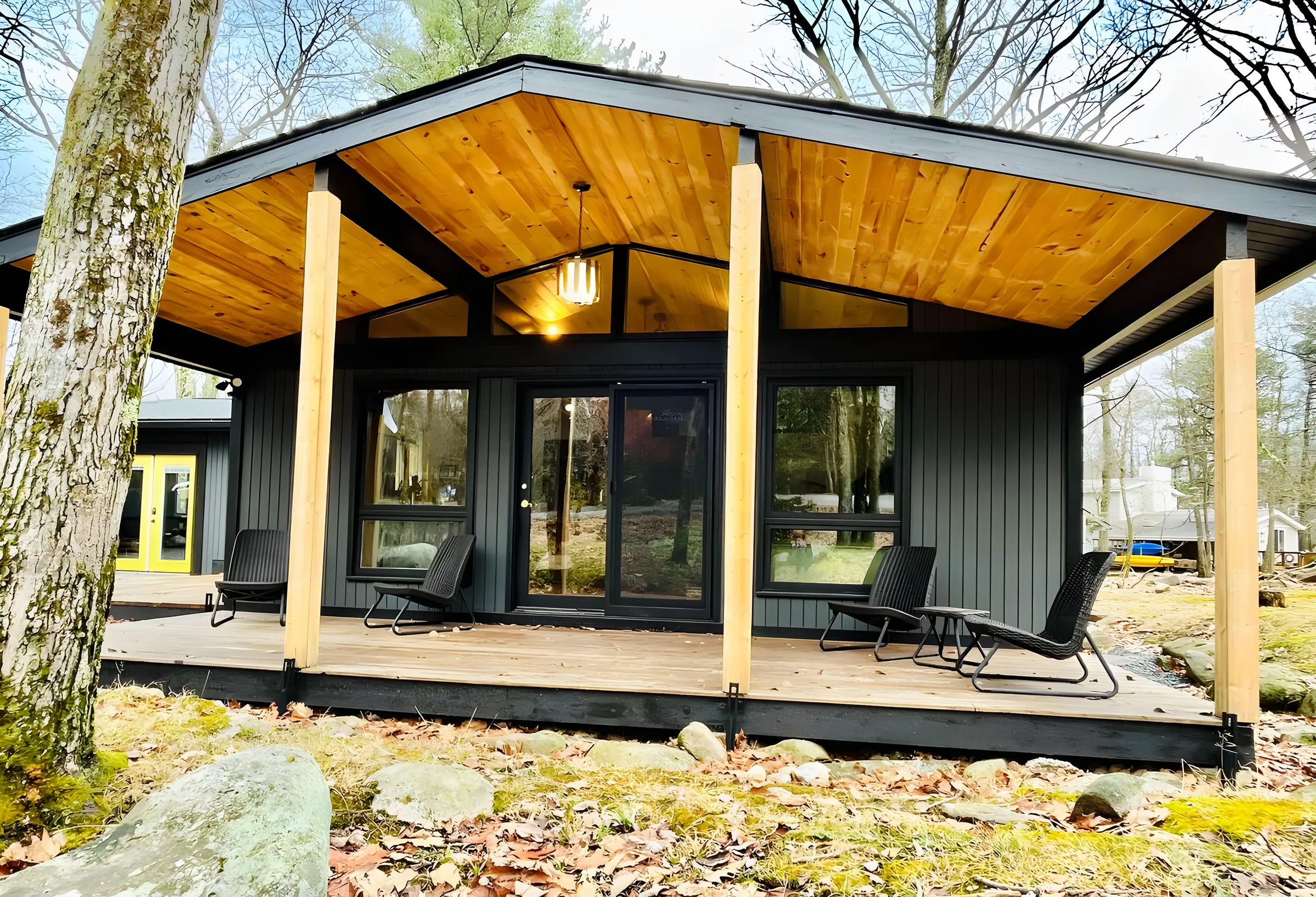 Modern black cabin with covered cedar porch and glass front at The Love Shack, Lake Harmony, PA
