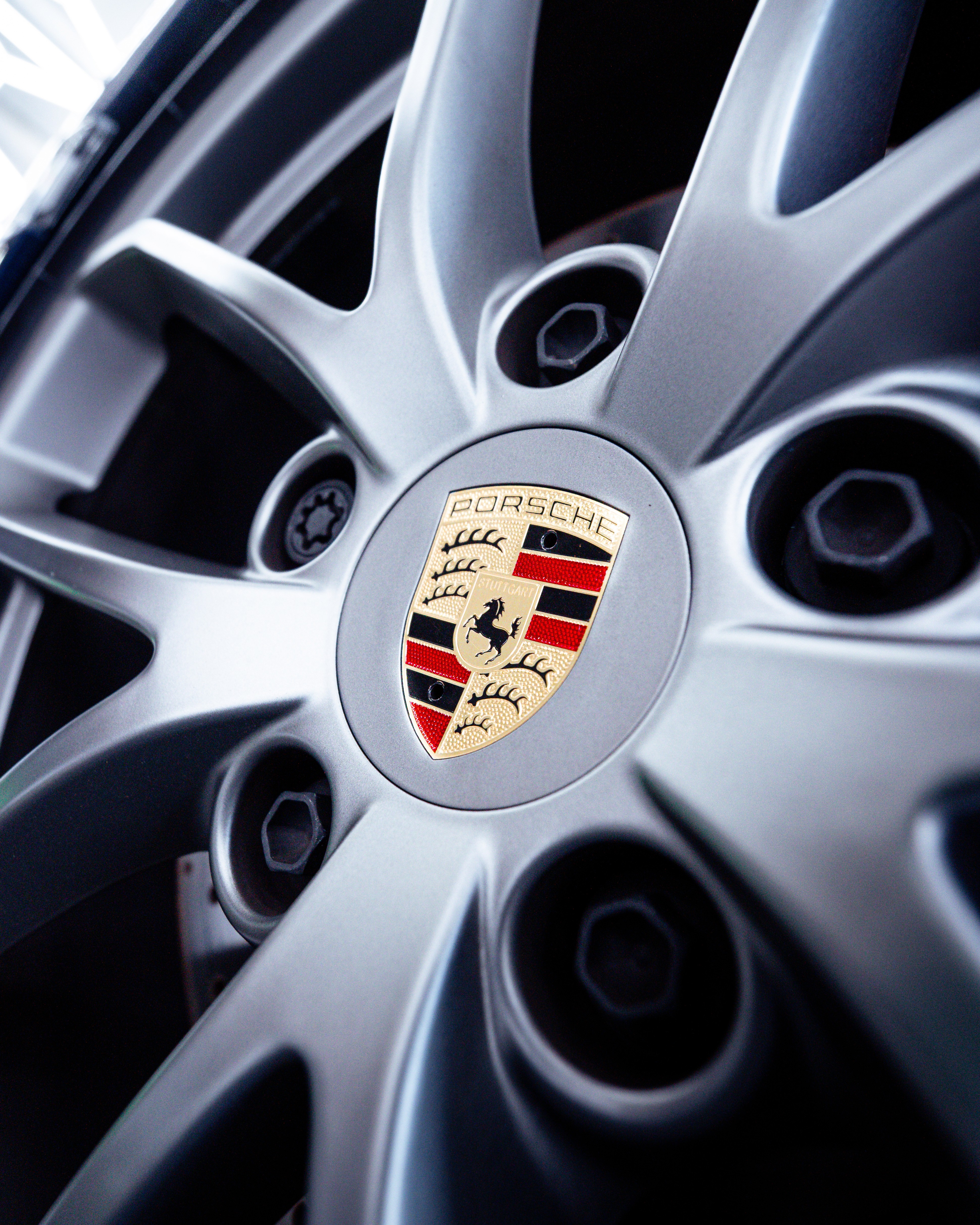 Wheel hub badge detail on a dark blue Porsche Spyder, at Dragon Auto in Milpitas