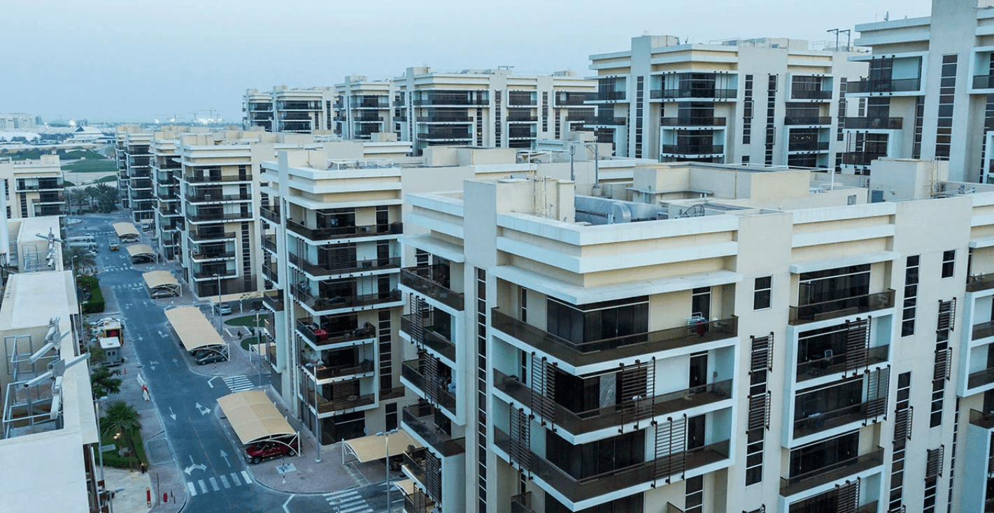 A large apartment complex in Khalifa City featuring numerous balconies on its multiple floors.