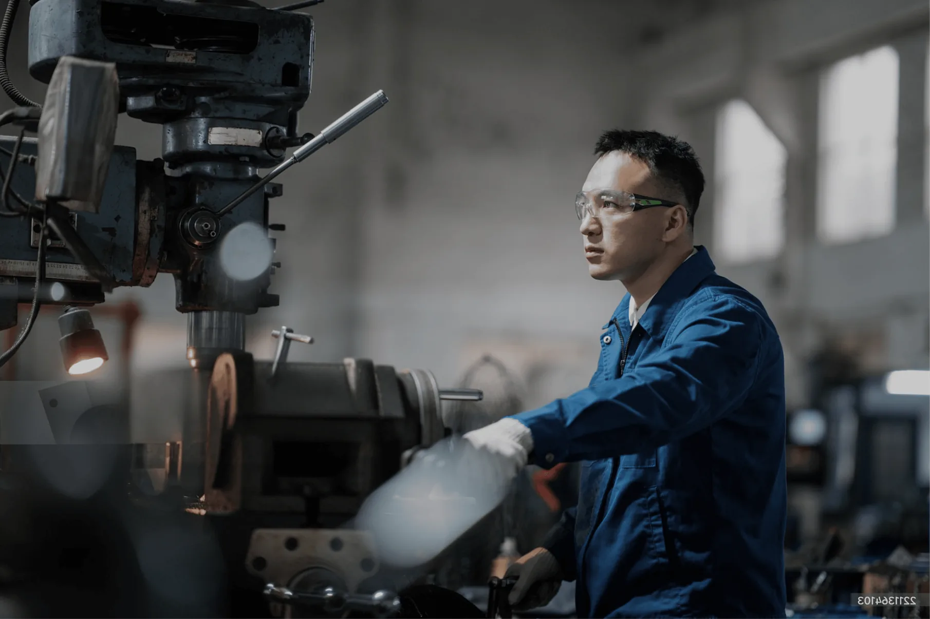 Engineer in safety glasses operating an industrial machine