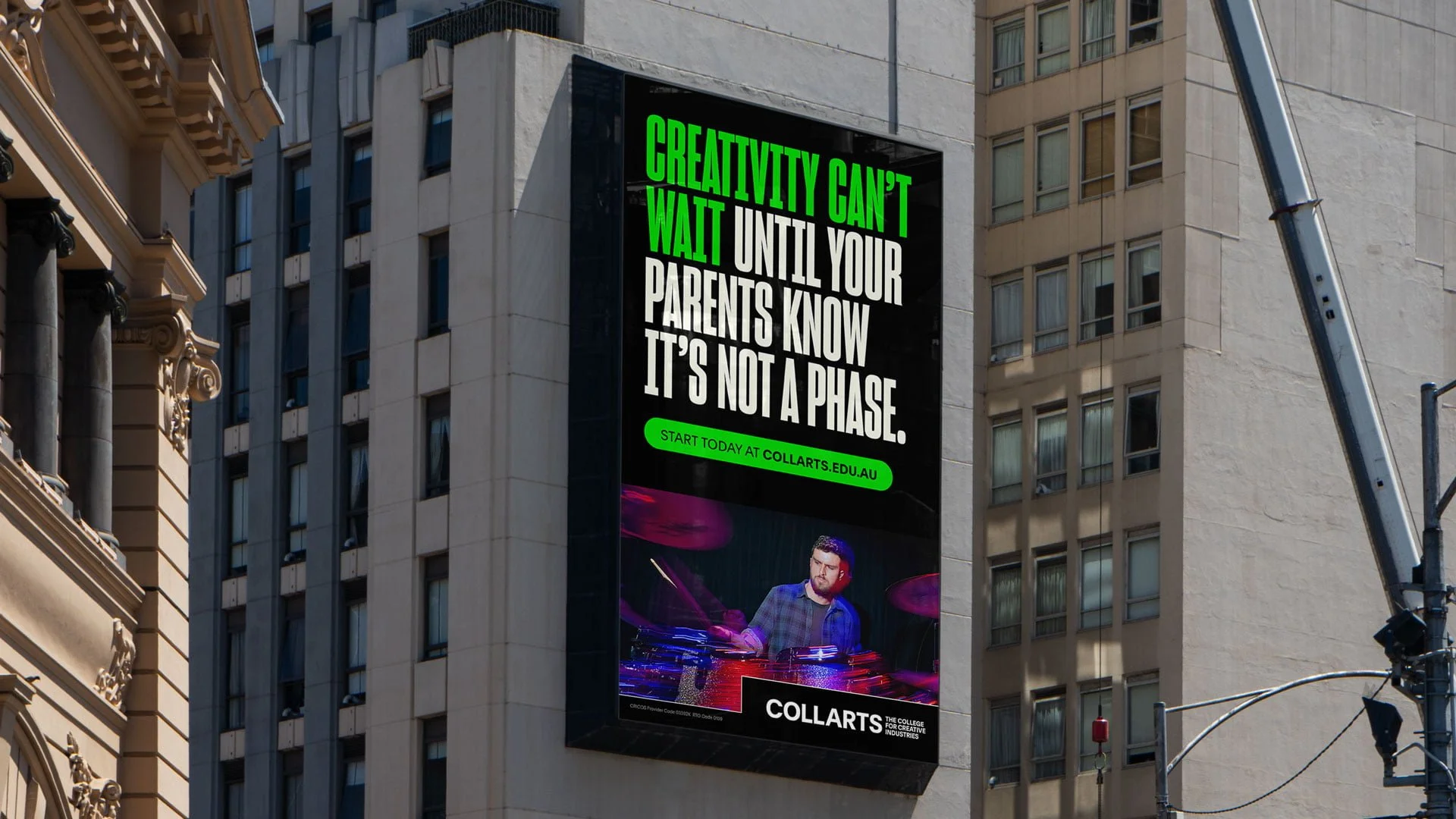Building-side screen for Collarts: 'Creativity can't wait until your parents know it's not a phase.' with a drummer