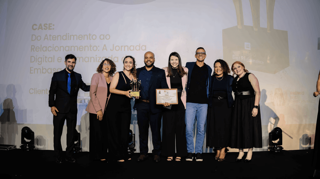 Executivos da EMBASA posando com troféu e certificado no palco do Prêmio Best Performance 2025