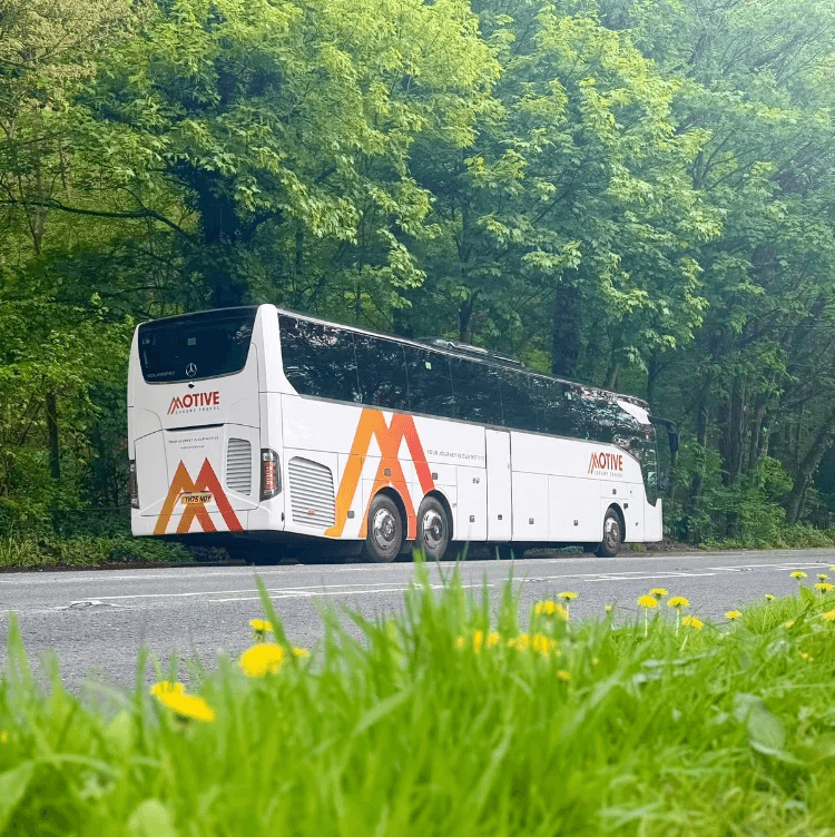 Luxury coaches and minibuses parked in urban and business districts, representing Motive’s professional chauffeur and corporate transport services focused on comfort, safety, and reliability.