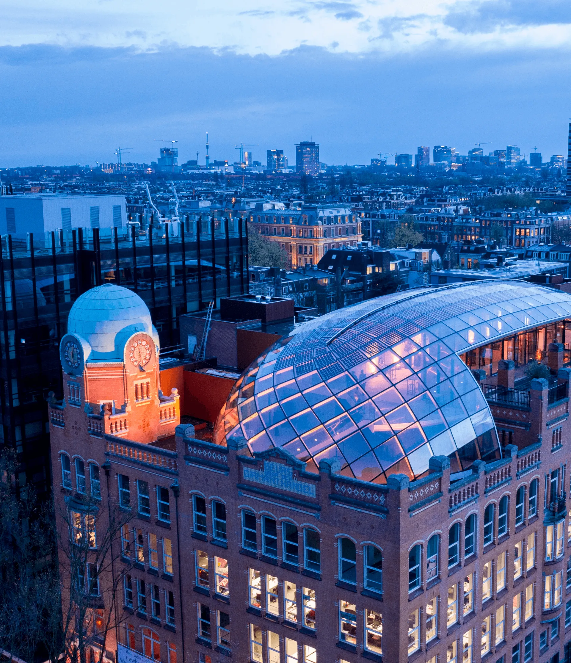 A view of a city skyline at dusk, featuring large cartoon figures on a rooftop.