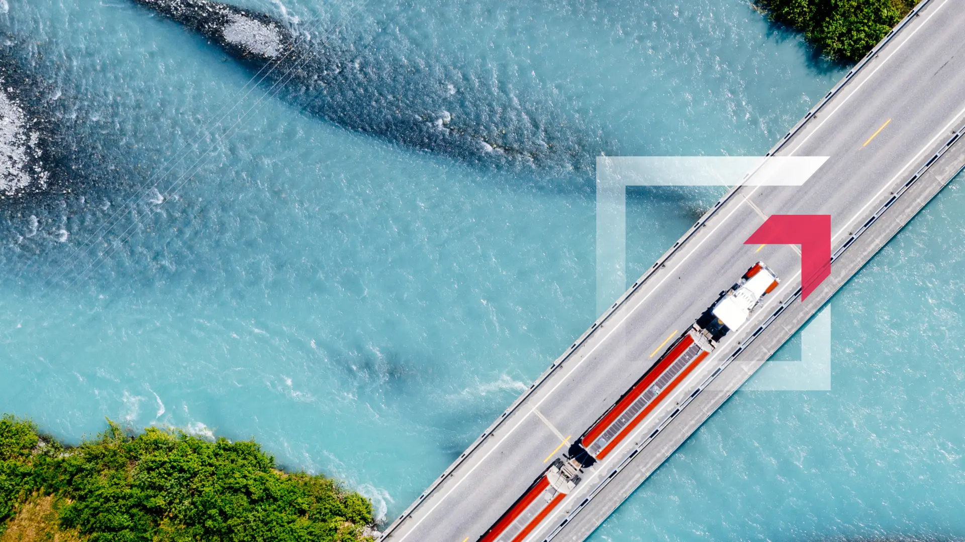 Aerial view of a semi-truck driving across a bridge over blue water representing commercial truck insurance services by GIA Group, LLC