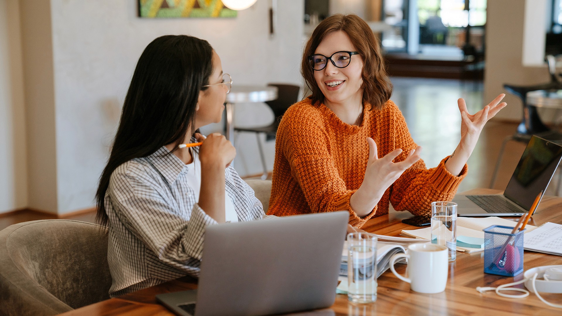 Women discussing data migration in office