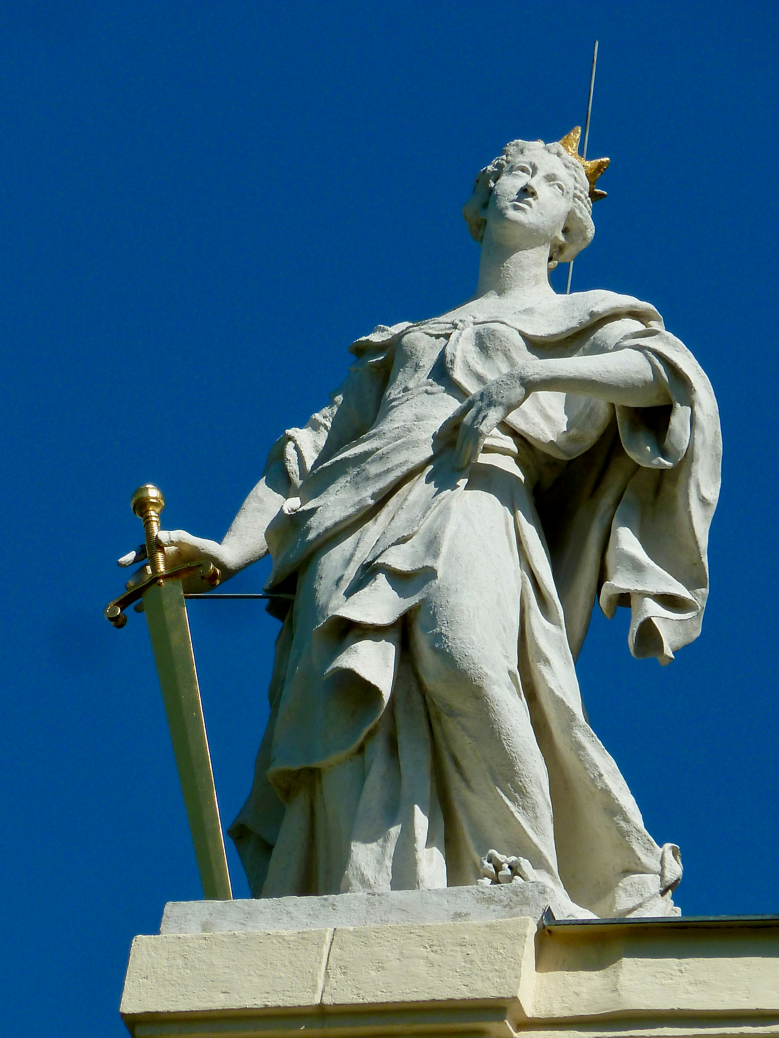 angel holding cross statue during daytime