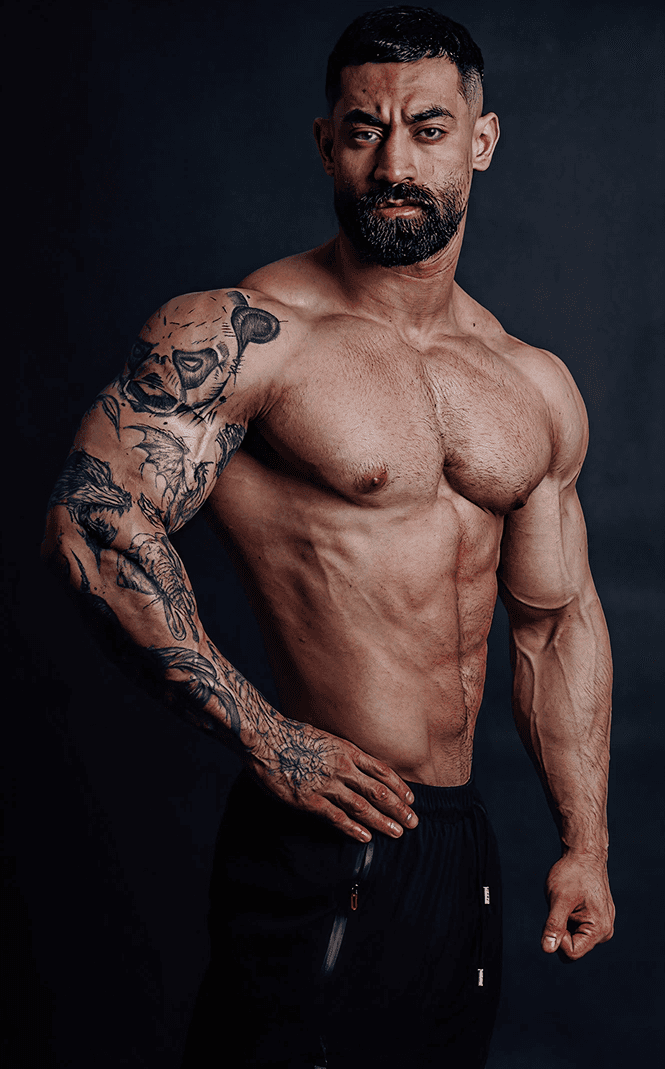 Muscular man posing shirtless after completing an 8-week fitness transformation, showing increased muscle definition.