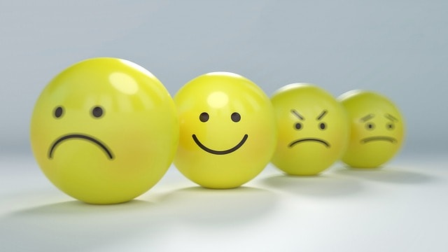 Happy smiley face in the foreground with negative smileys blurred out