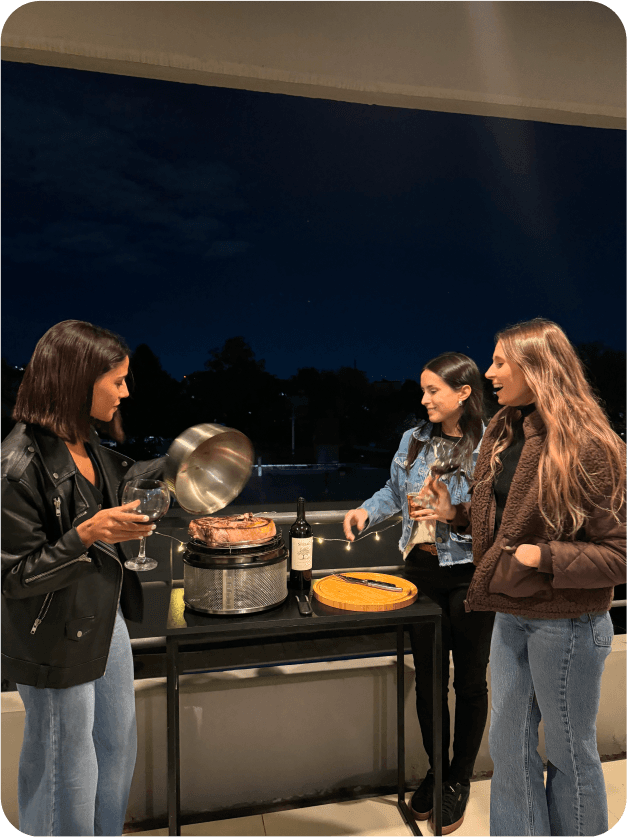 Un grupo de amigas en un balcón haciendo un asado en su COBB Premier