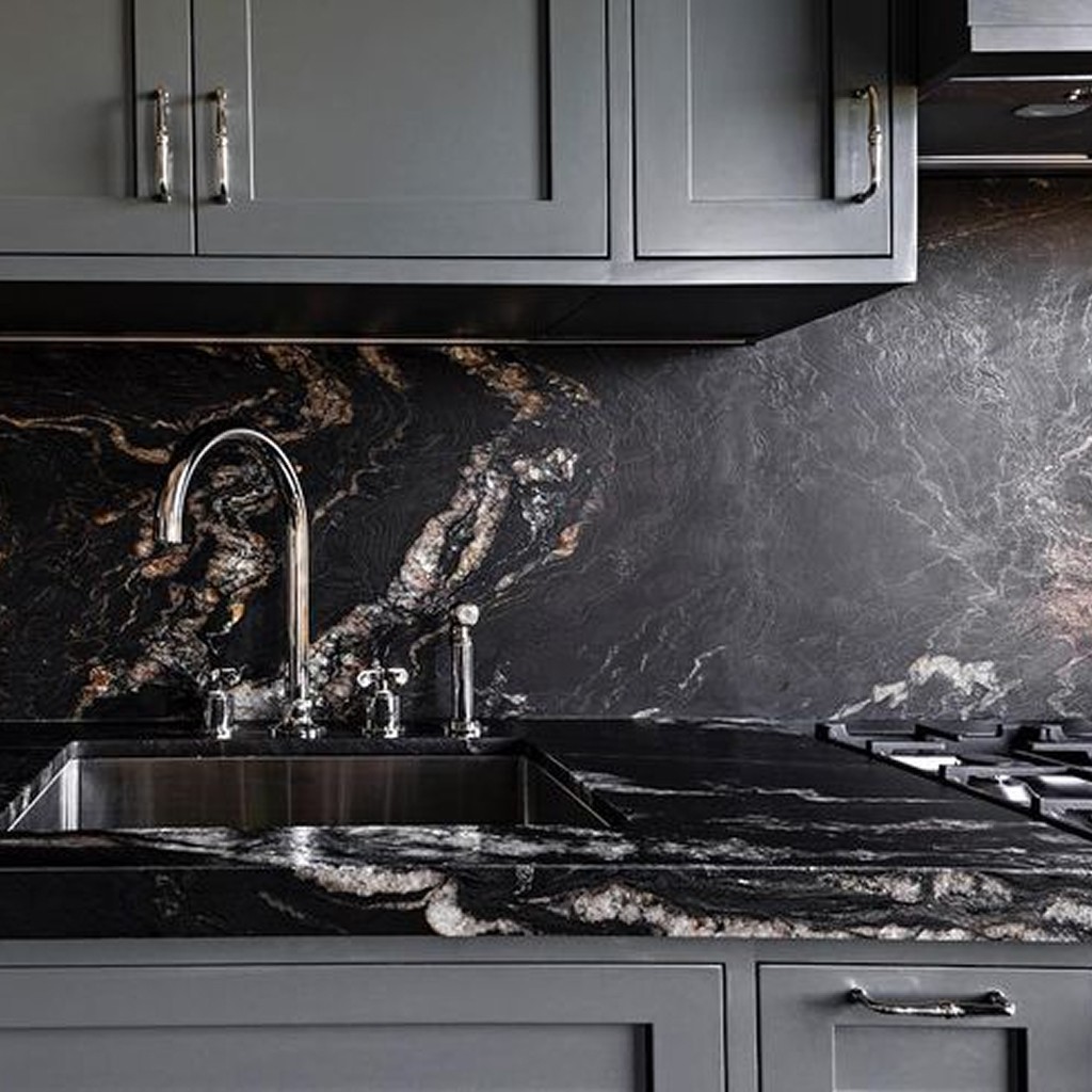 Titanium Gold leathered granite countertop and full-height backsplash in a dark kitchen