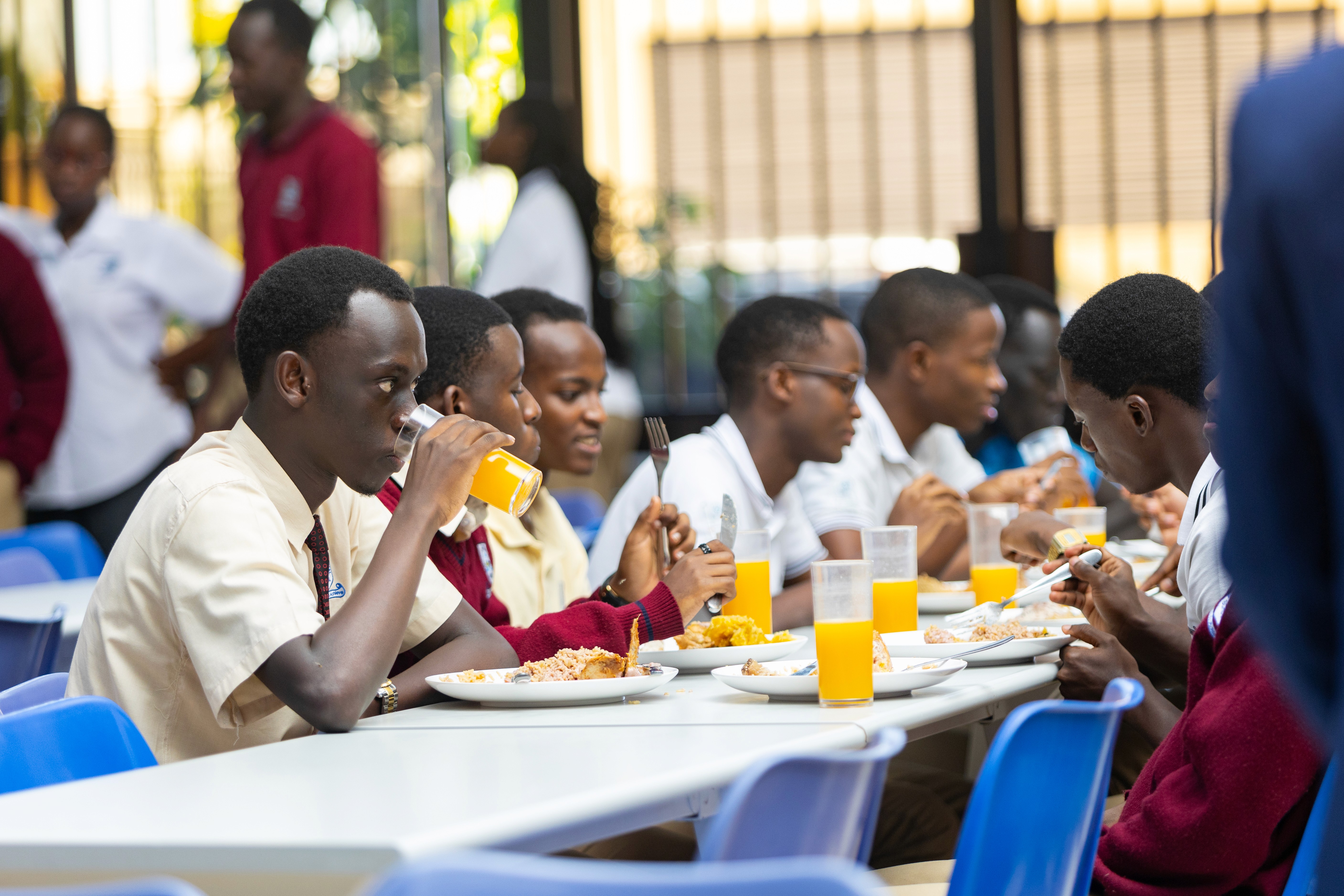 Two cheerful students are balancing books on their heads, smiling and laughing