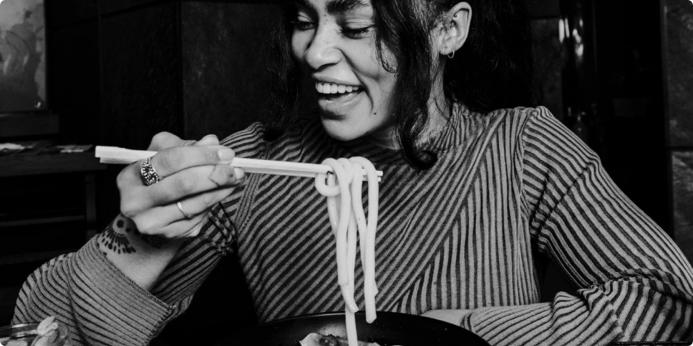 a woman eating noodles