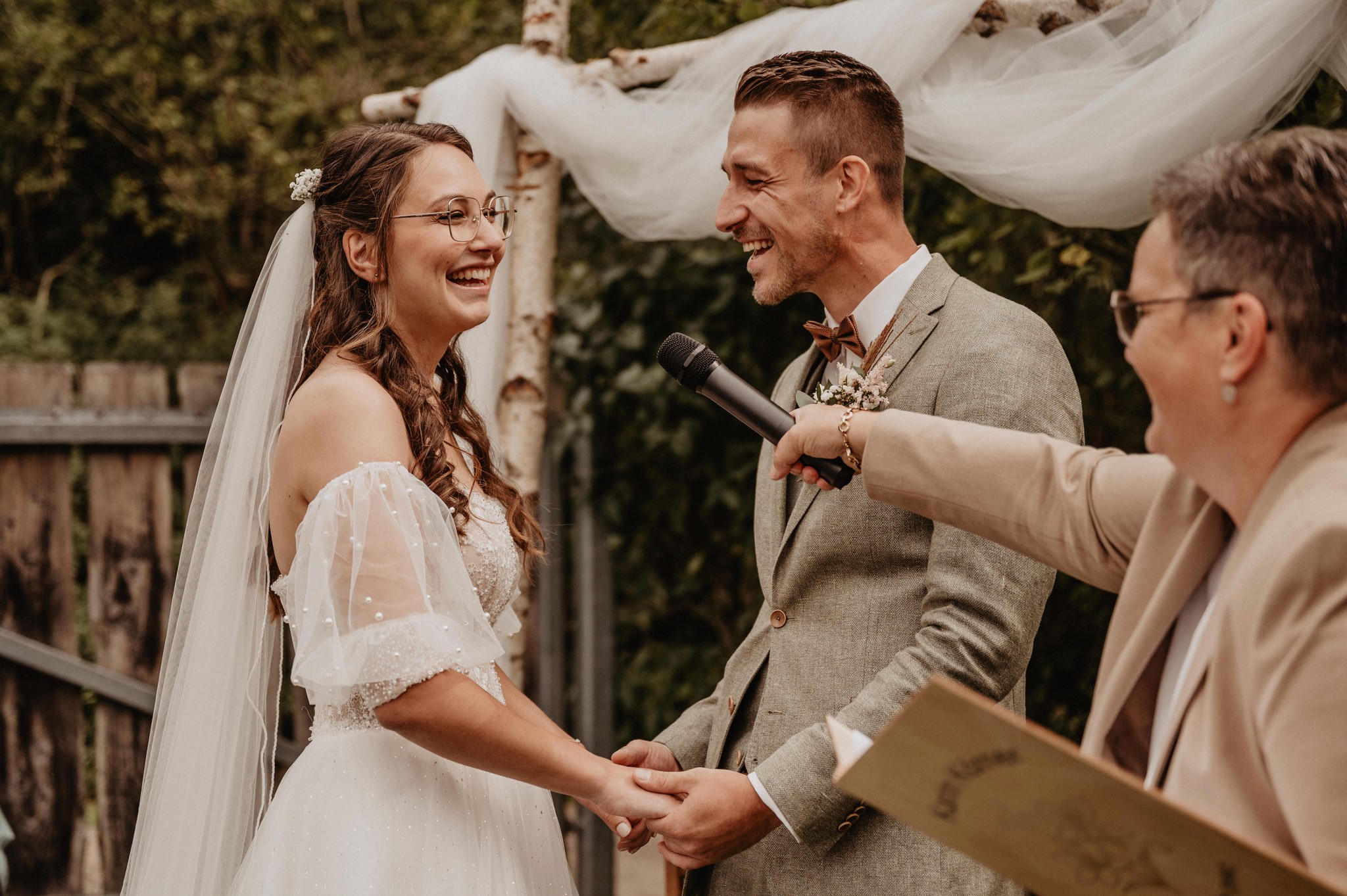 Ein glückliches Paar lacht während der Trauzeremonie – Nicole Grasmann fängt die Liebe und Wohlfühlatmosphäre eurer Hochzeit ein