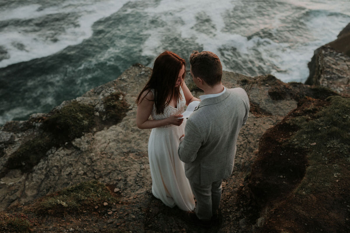 elopement couple saying vows at cliffs of moher overlooking the atlantic ocean