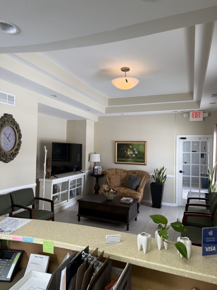 Comfortable dental patient waiting room featuring a flat-screen TV, cozy seating, and professional decor to ensure a relaxing visit.