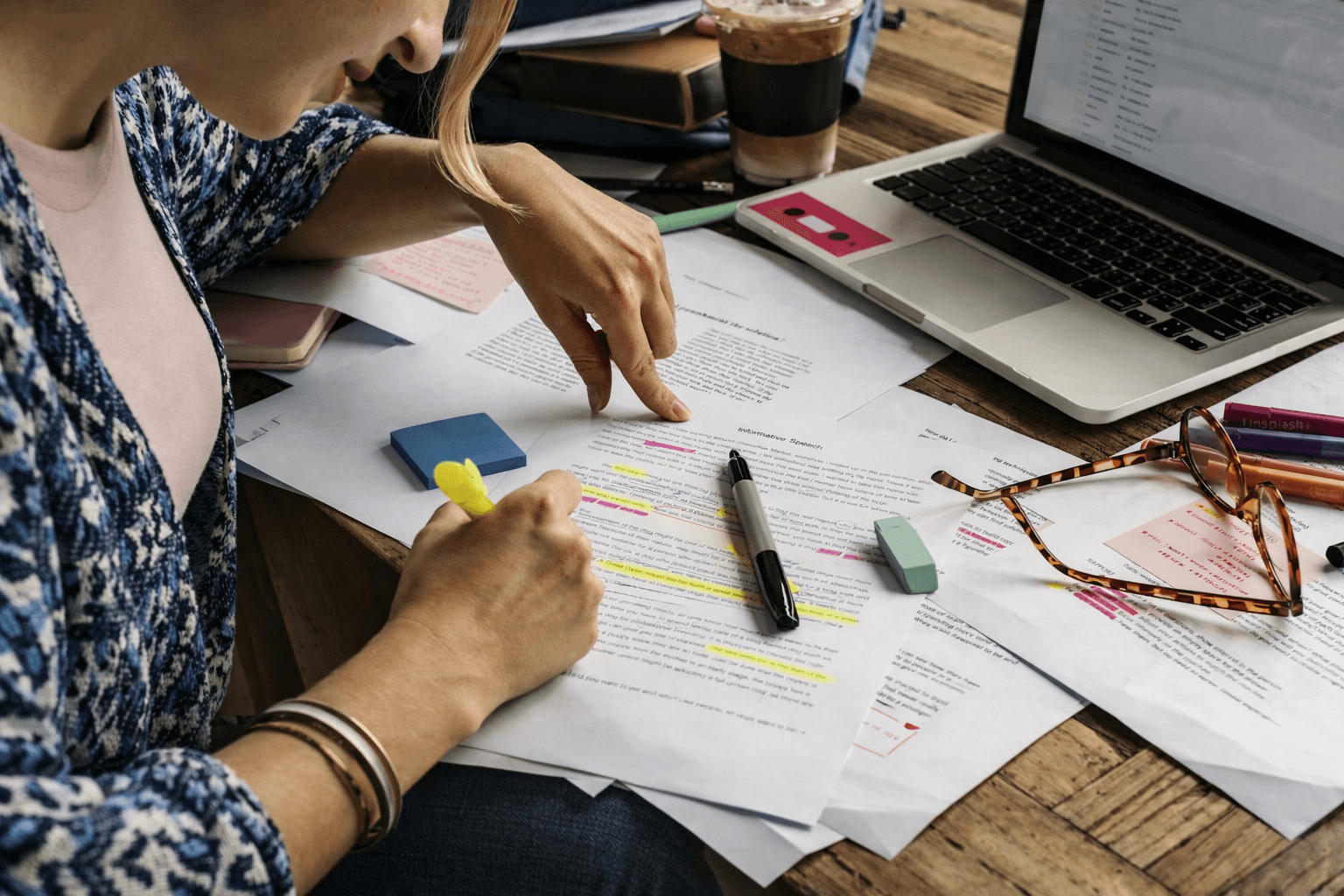 Person editing and reviewing an internship offer letter with a laptop nearby.