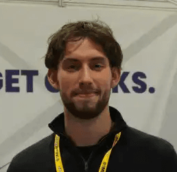 Profile portrait of a man in a white shirt against a light background