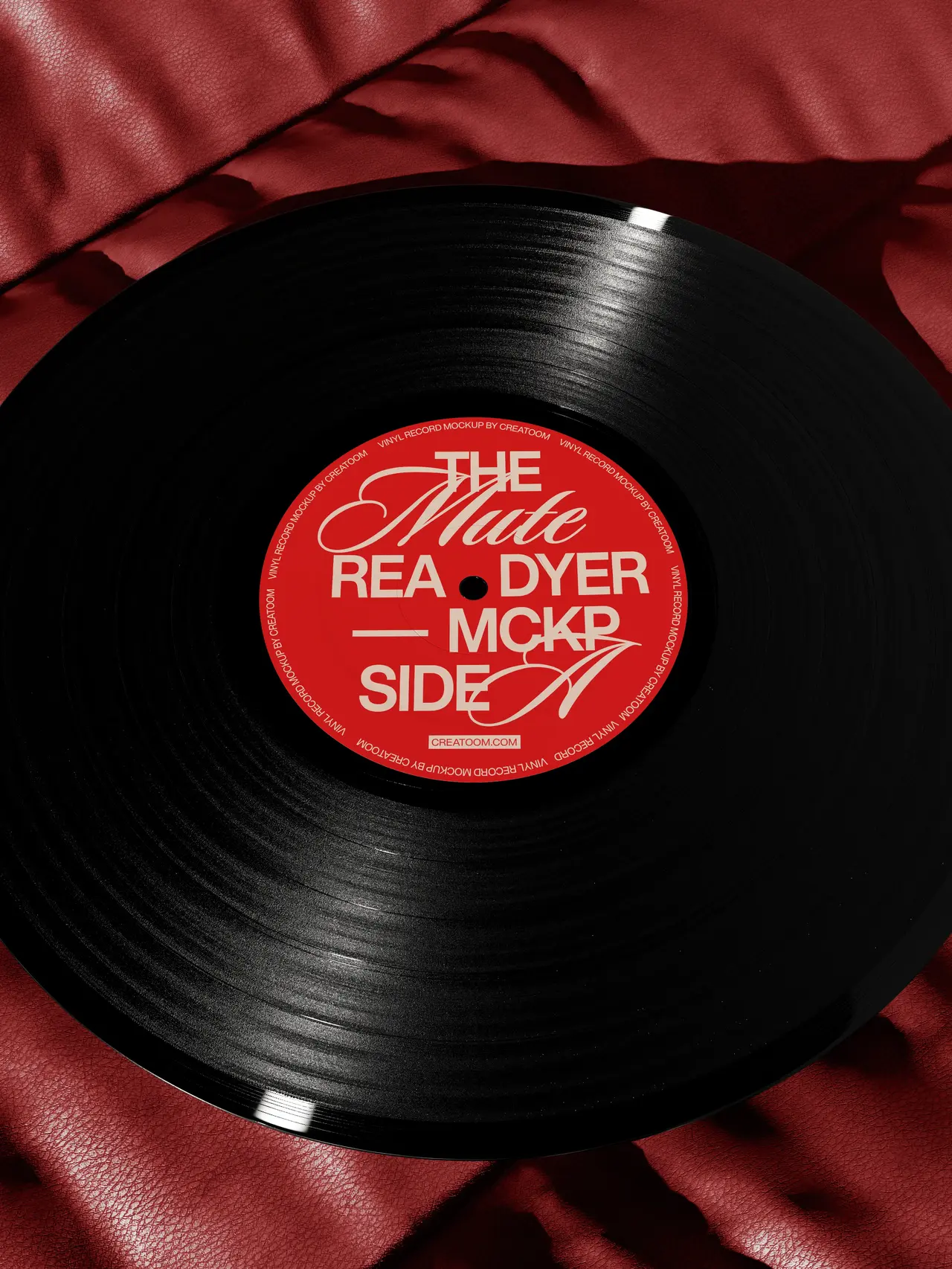 Black vinyl record with a red label on red fabric.