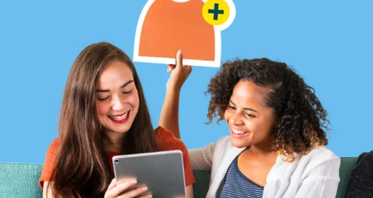Duas jovens sorrindo diante de um tablet, sobre fundo azul com a ilustração de uma camiseta