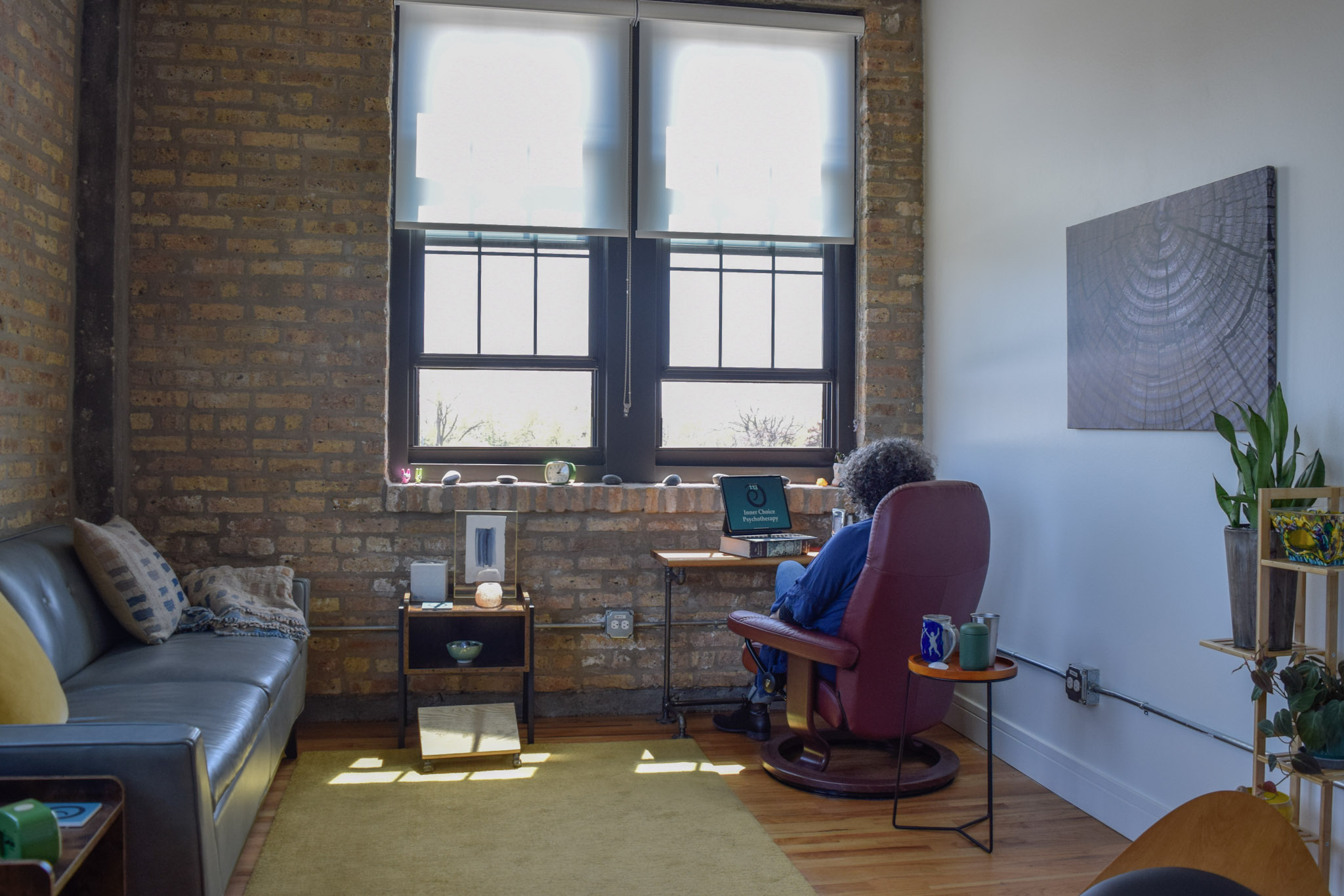 Annabeth Chickering, sitting at the desk in her office, providing remote therapy.
