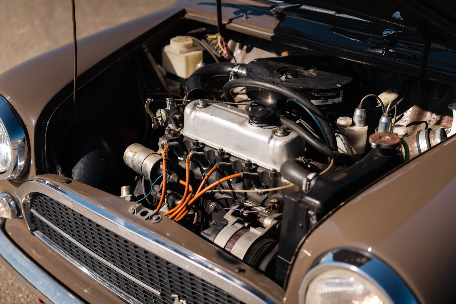 Close-up of a car engine, showcasing intricate components and wiring inside the hood of a vehicle.