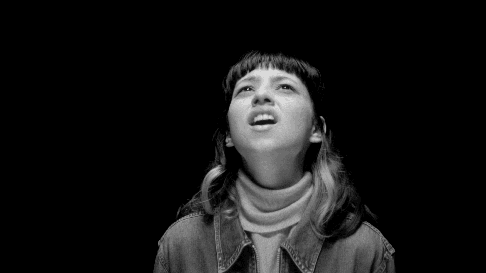 View of the French countryside through a stone villa’s open living room, with sofas and trees framing the scene