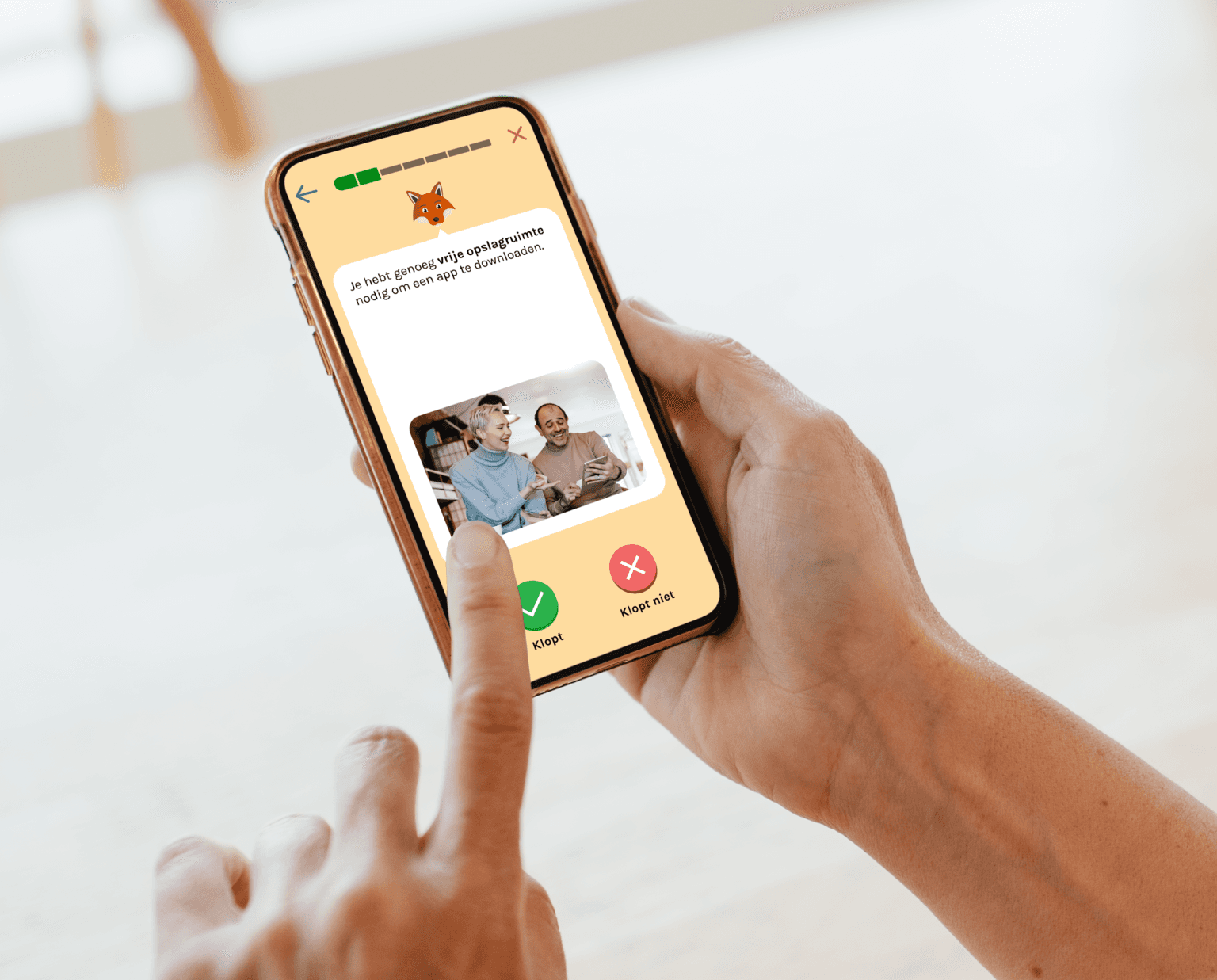 Foto van iemand met een mobiel in de handen. De app 'Digihandig' staat open.