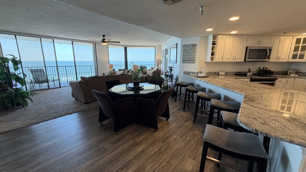 Dining table and breakfast bar beside ocean windows, Unit 1005 at The Ashley, a vacation rental in Daytona Beach Shores
