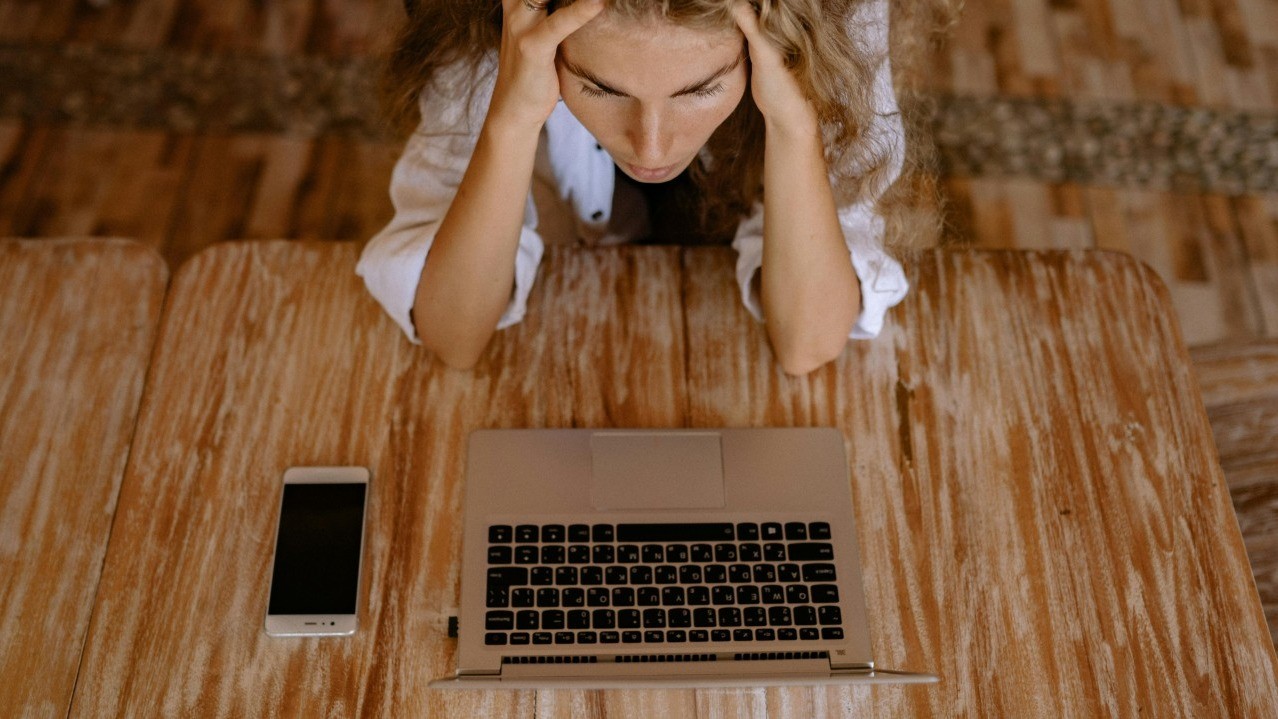 A person stressed out looking at their laptop screen
