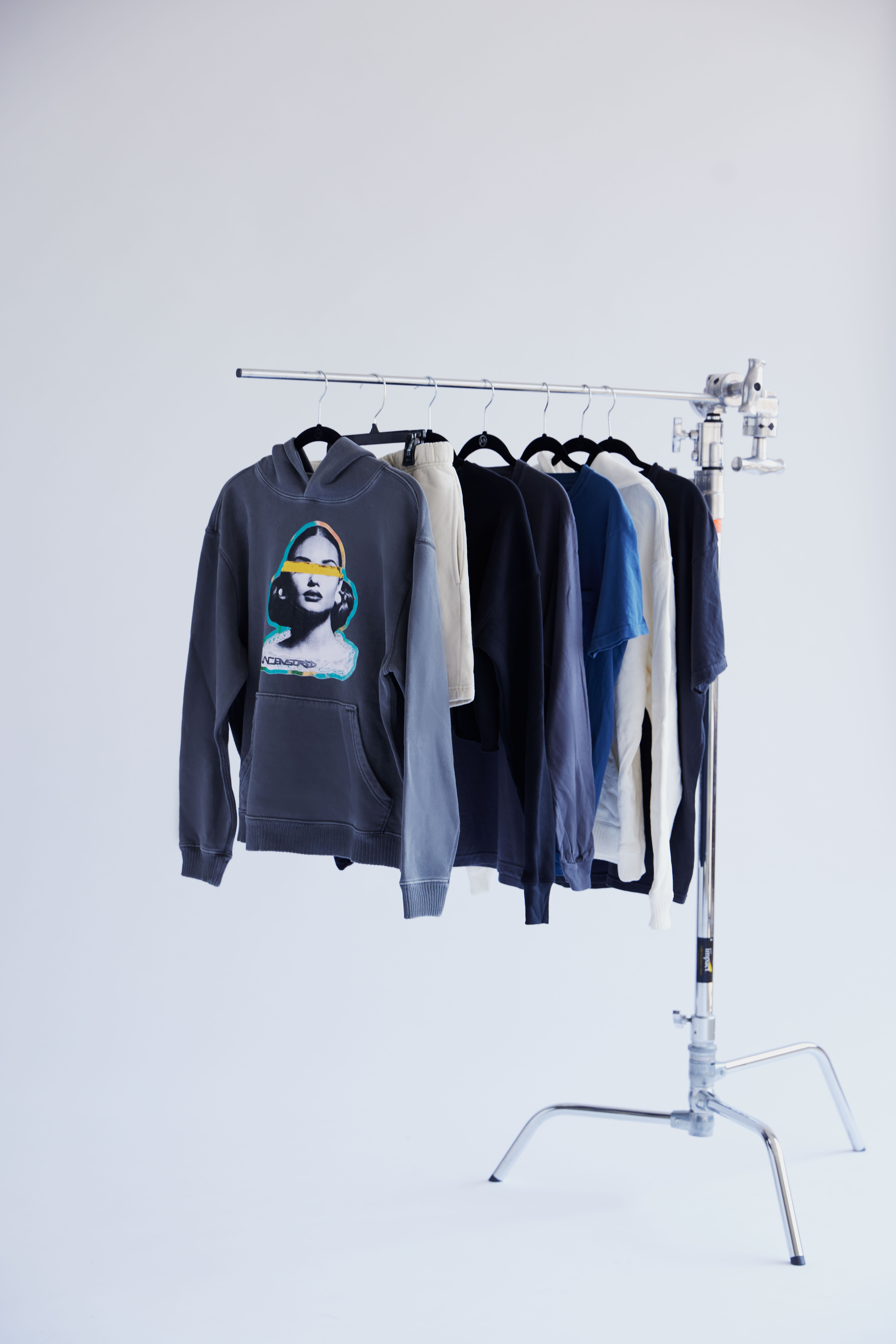 A tan sighthound stands in a grassy field.