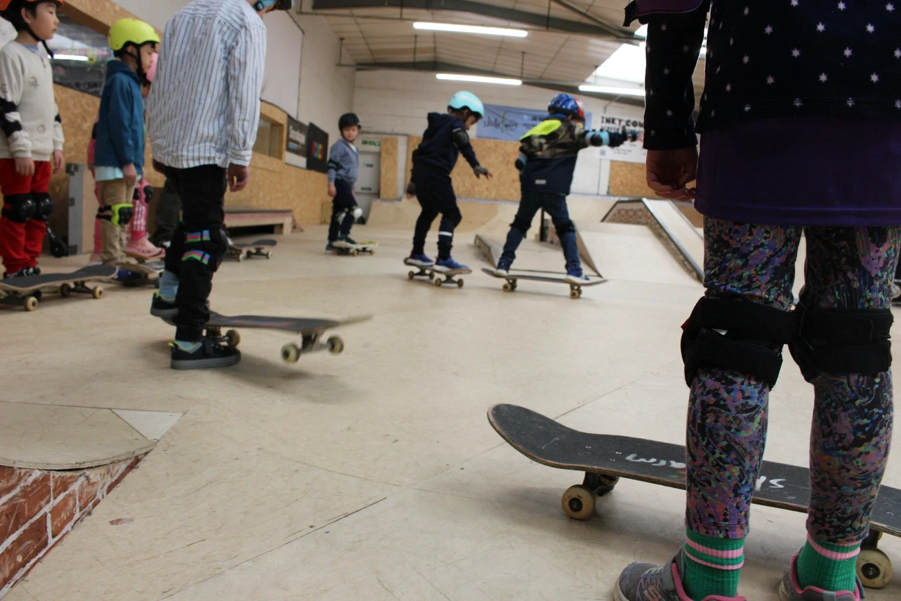 Children learning to skateboard during a kids session at The Skate Farm indoor skatepark, Haywards Heath