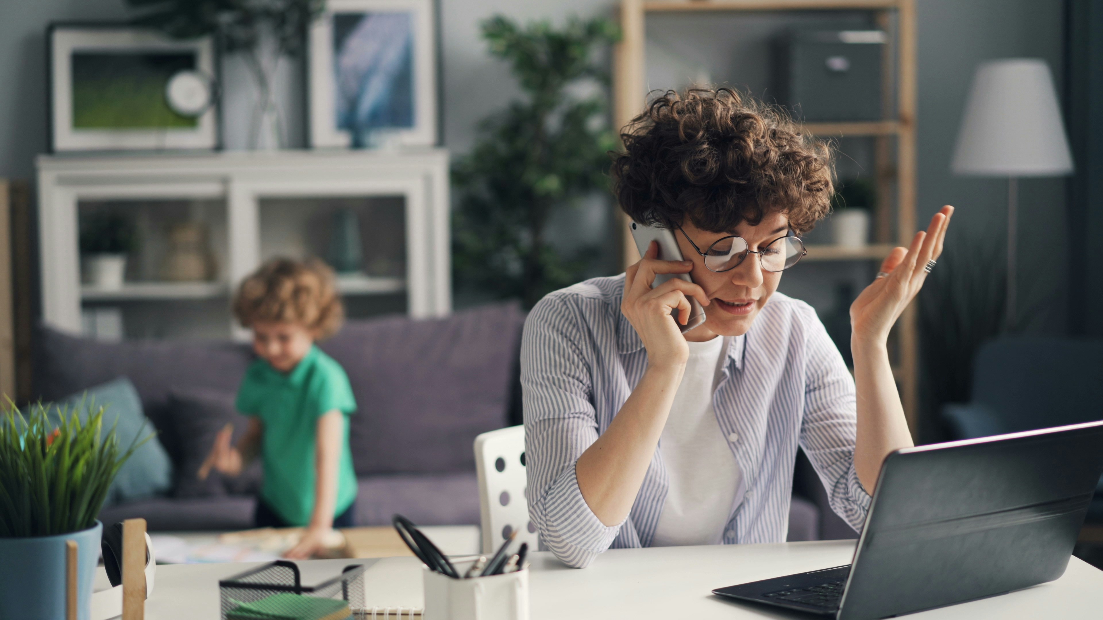 a woman sitting at a table talking on a cell phone