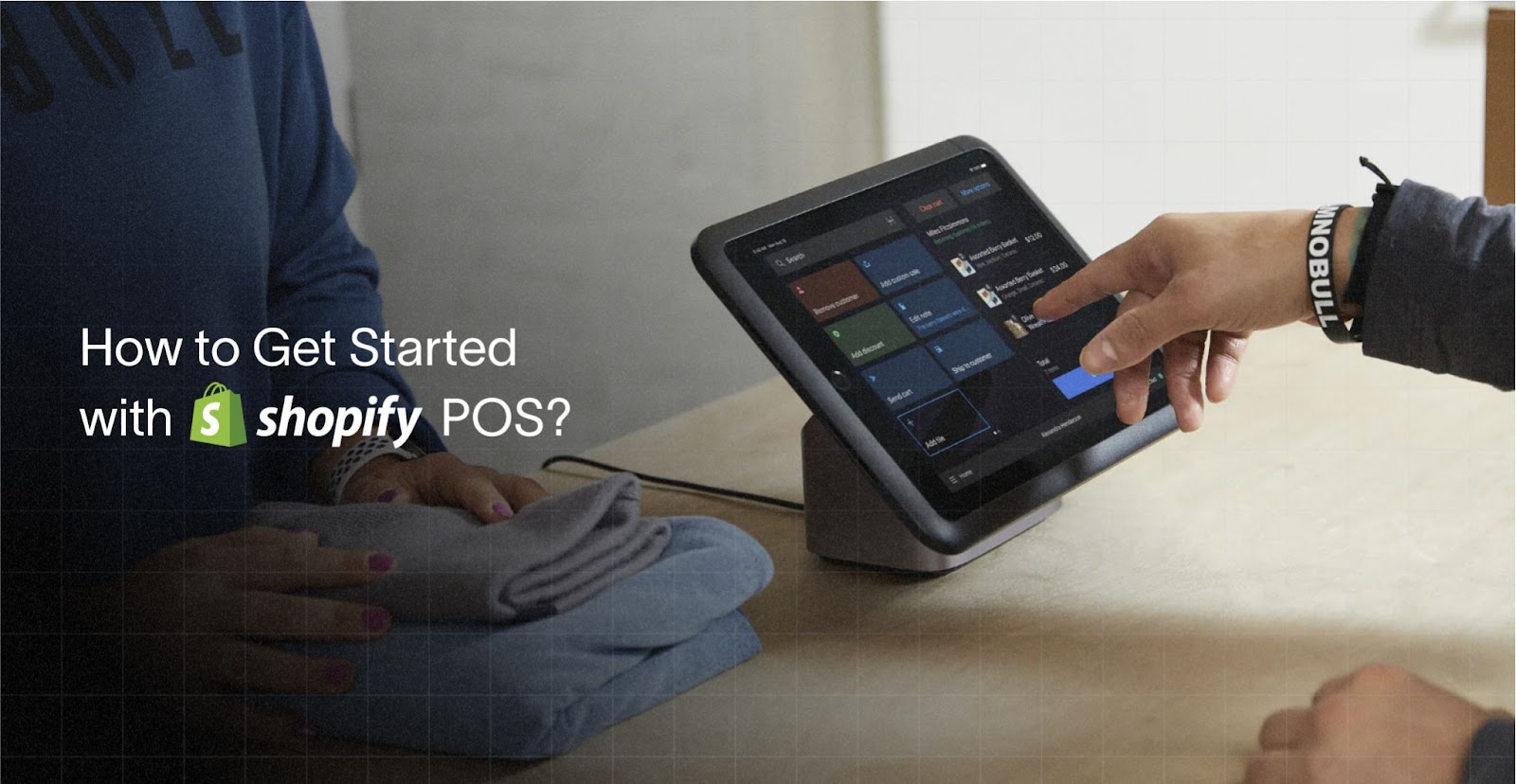 Mitarbeiter bedient ein Shopify POS-Terminal an der Ladentheke mit gefalteter Kleidung