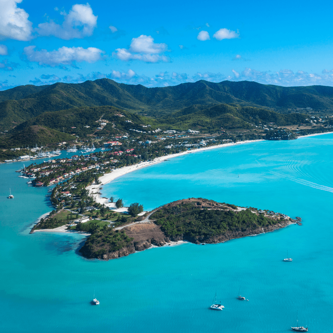 Vue aérienne d’une baie en Martinique bordée de collines verdoyantes et d’eau turquoise, décor idéal pour ralentir et se recentrer