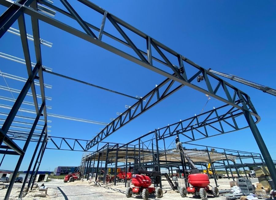 Montage d’une ossature métallique sur un chantier sous ciel dégagé.