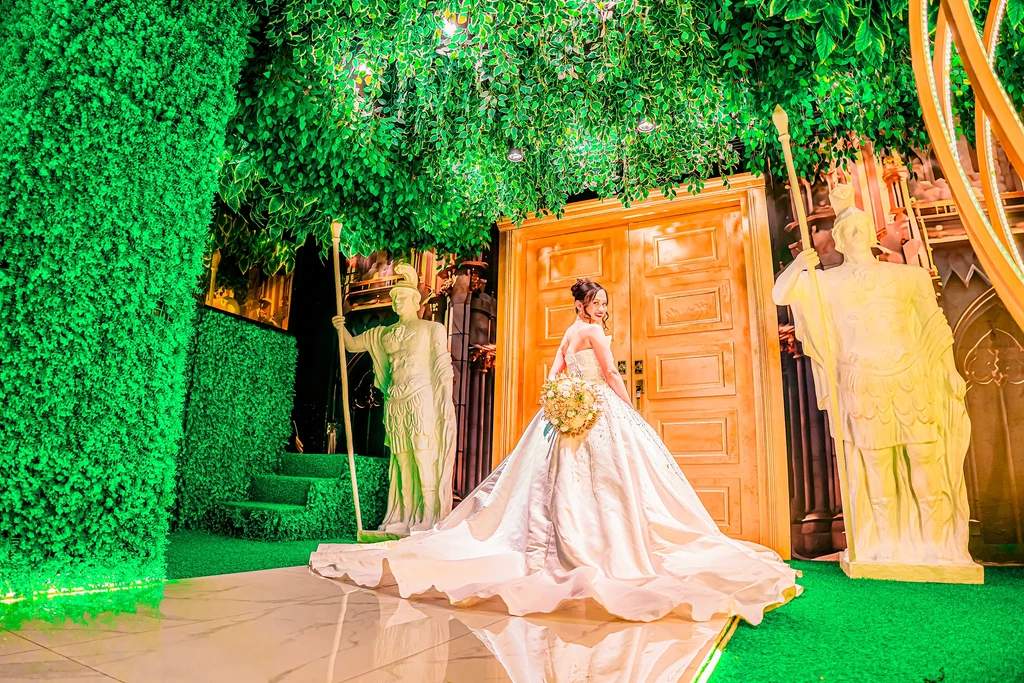 Bride with a long train walking the enchanted forest aisle of Pandora Hall, Quezon City
