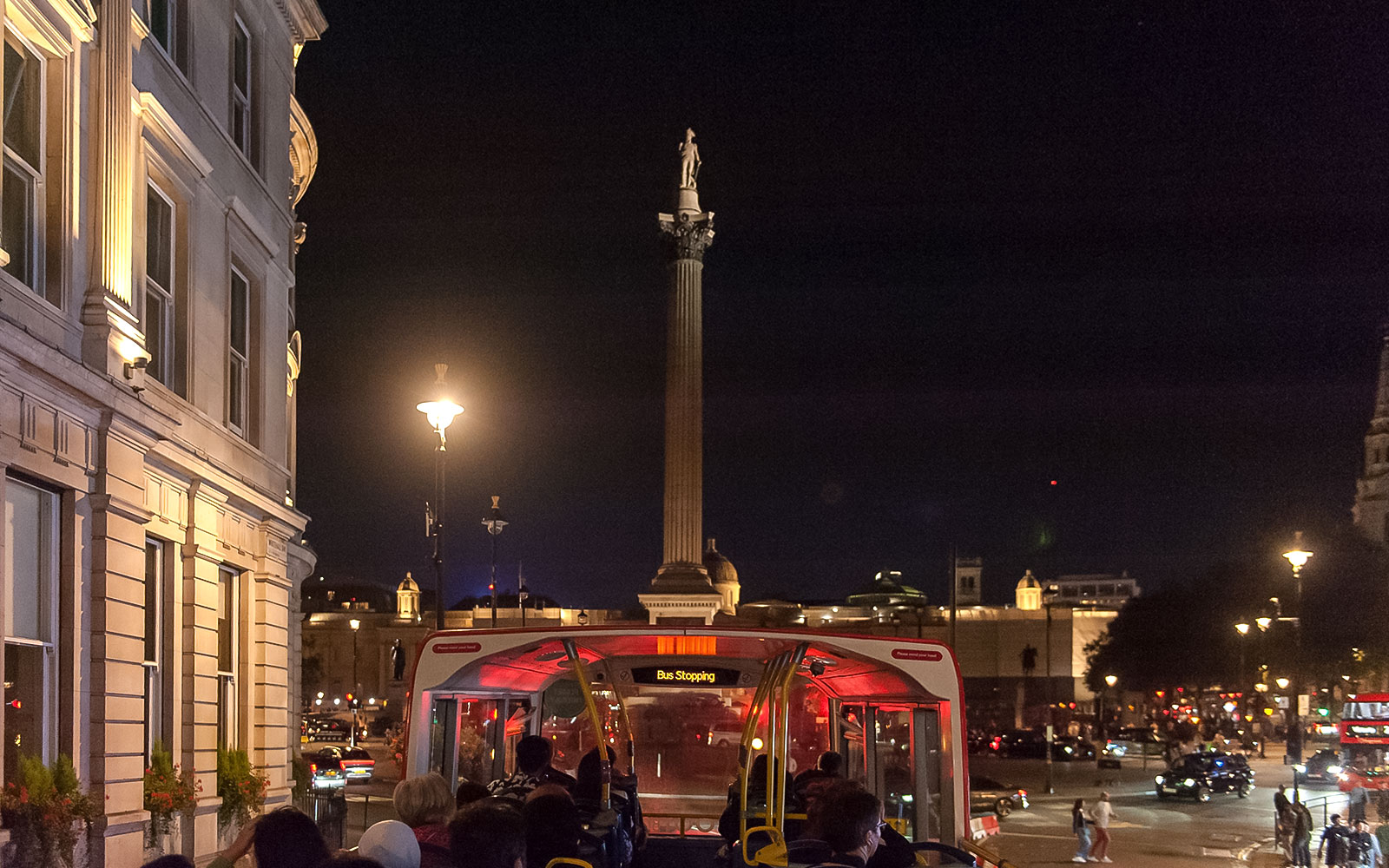 Visite en bus à impériale la nuit près de la colonne de Nelson, Londres.