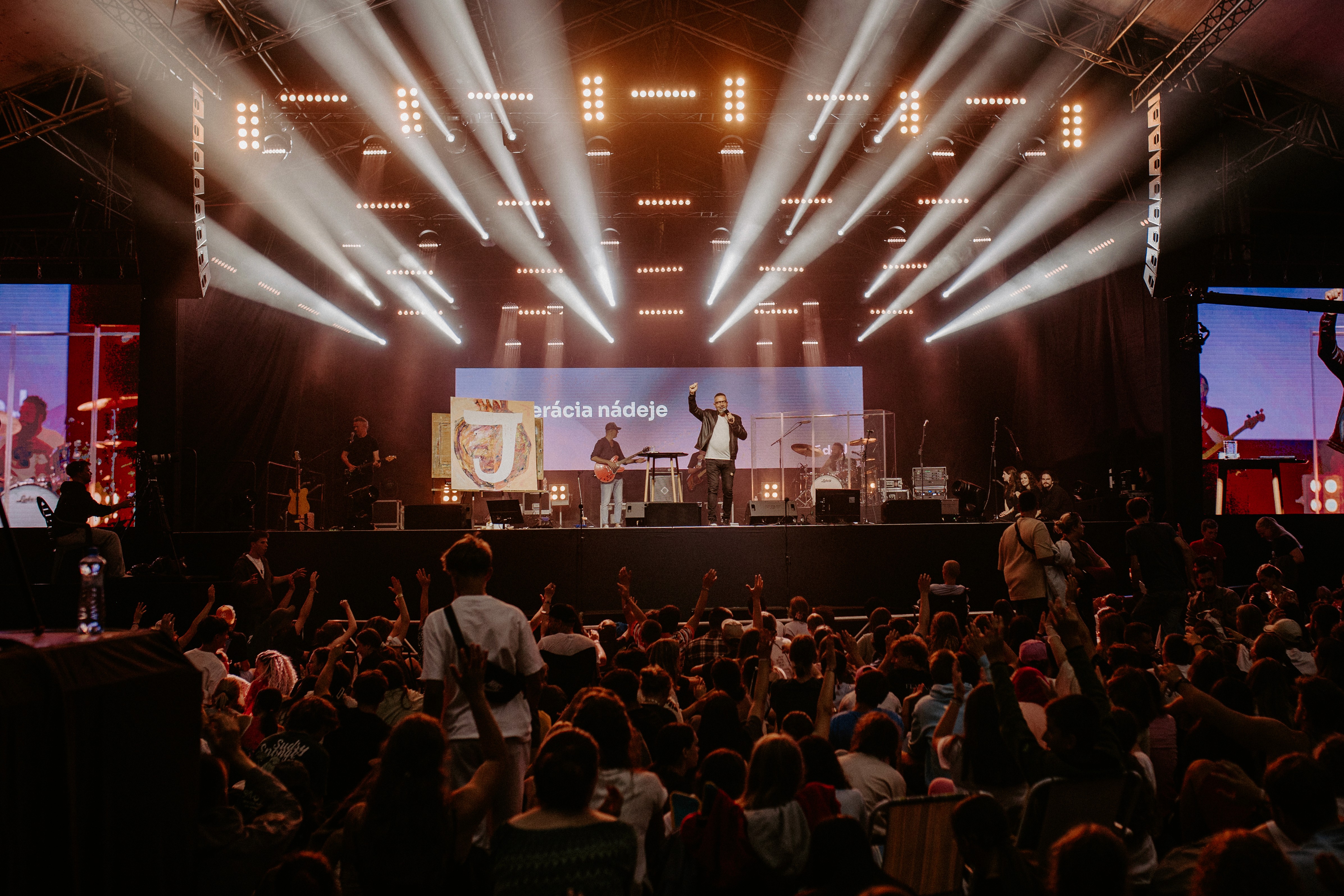 Lively crowd raising their hands toward a stage
