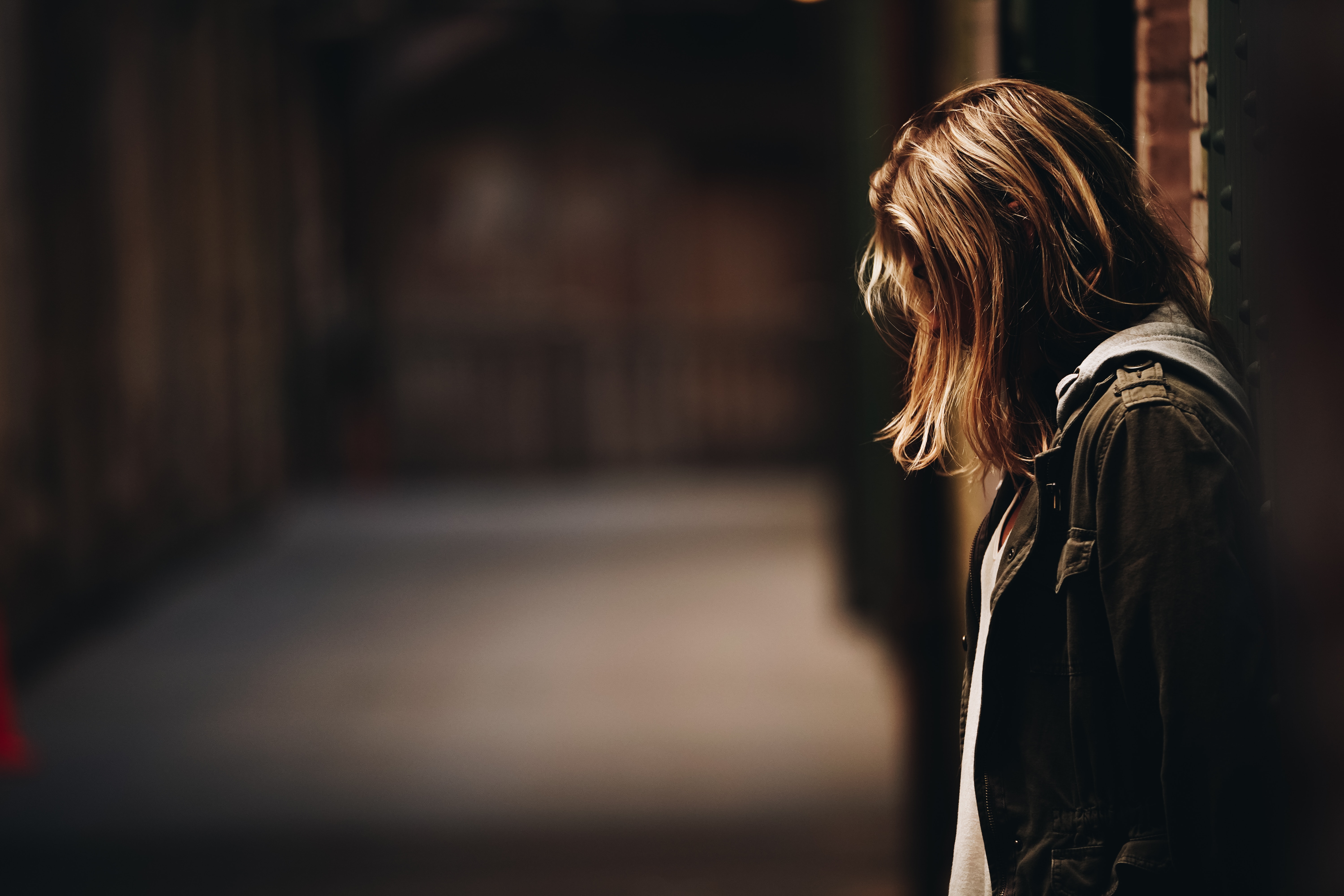 A stylised image of a woman in focus, her hair is covering her face 