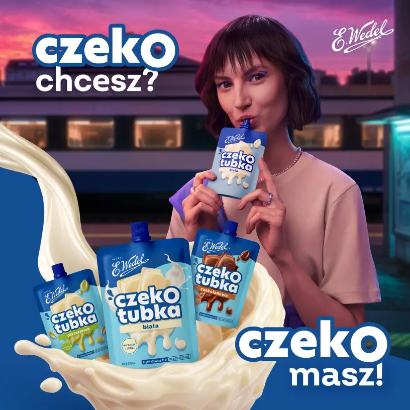 Kobieta z tubką białego kremu Wedel na tle wieczornego miasta