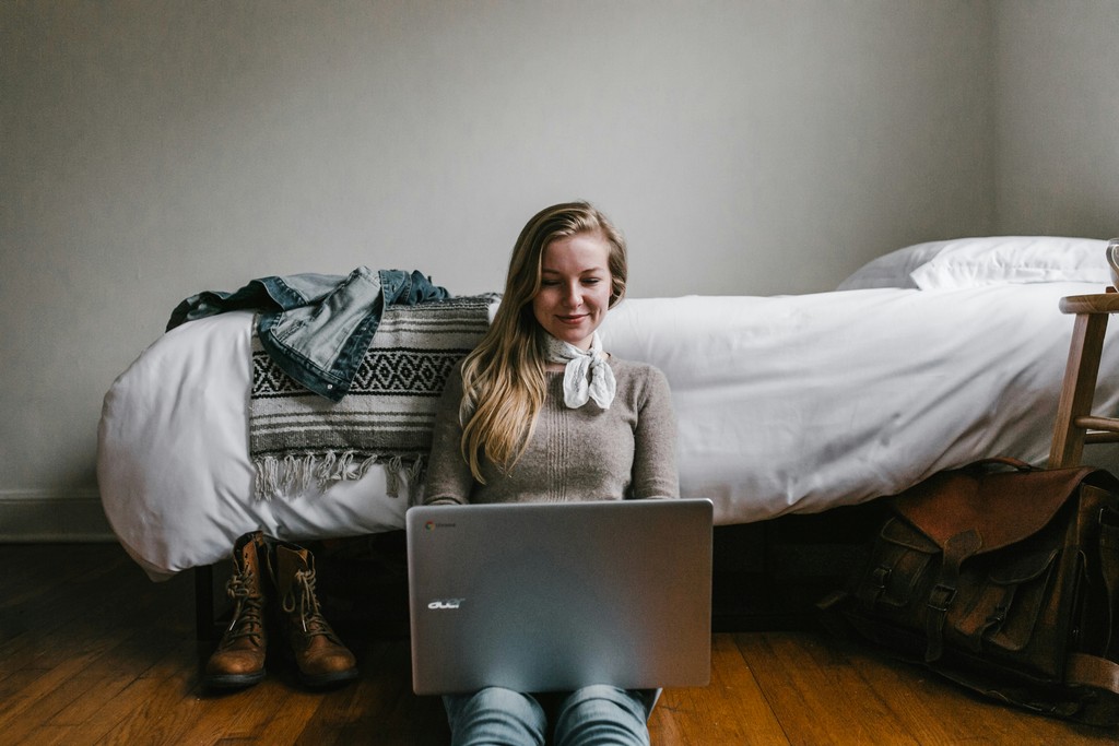 woman sitting on the floor with her laptop shopping for clothes online