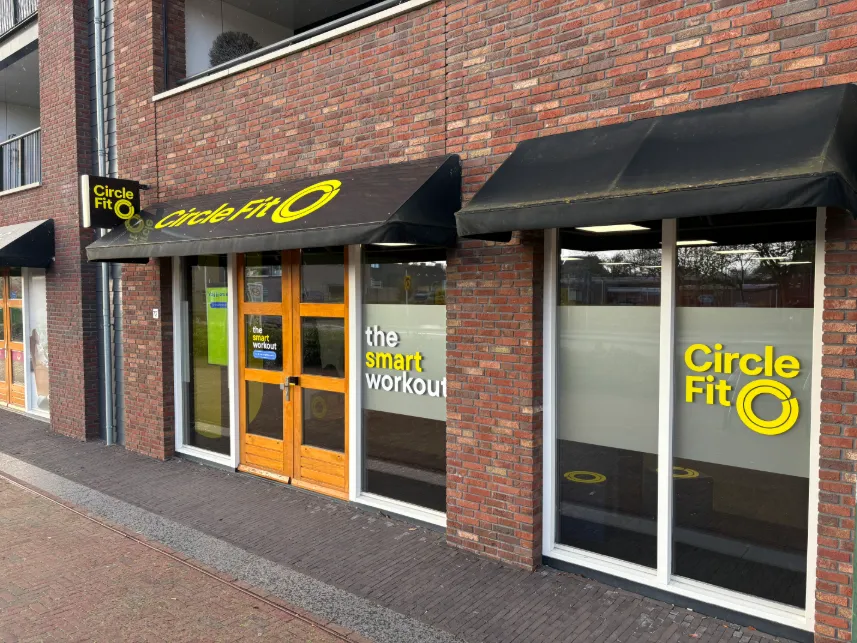 Image of a hub with large windows featuring signage and a prominent logo of Circle Fit, located in an urban area.